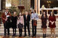 a group of young people standing in front of a church