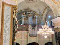 the interior of a church with an ornate organ and chandelier